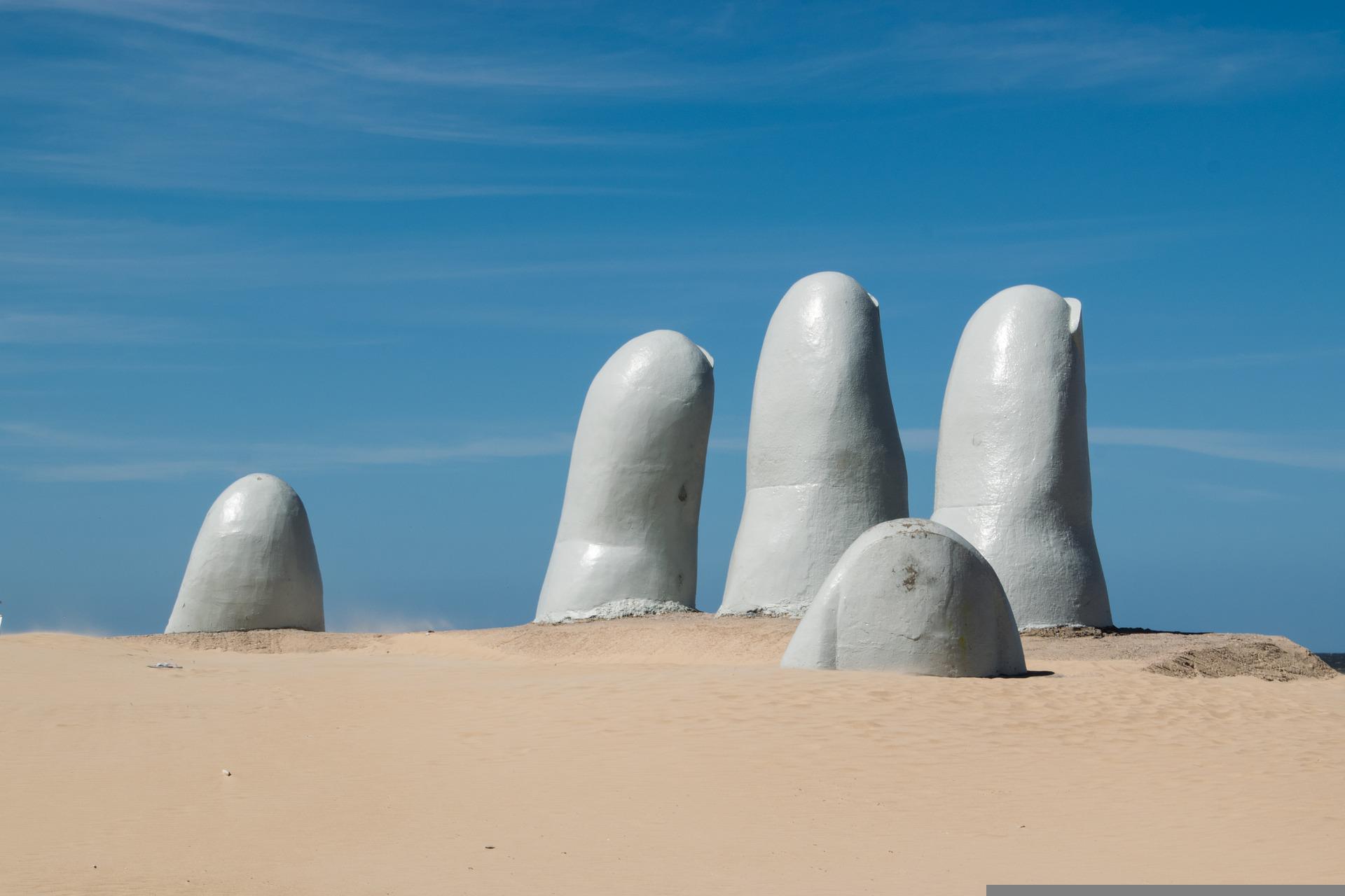 A picture of a giant hand in the sand